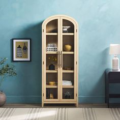 a room with a blue wall and a wooden bookcase in the corner next to a potted plant