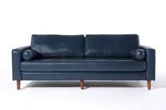 a blue leather couch sitting on top of a white floor next to a wooden frame