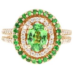 This beautiful ring has a Oval Cut Tsavorite that is 1.14 Carats. It is embellished with 26 Round Cut Tsavorites that weigh 0.36 Carats and 48 Round Cut Diamonds that weigh 0.46 Carats. The total carat weight of the ring is 1.96 Carats. Tsavorite is a natural stone that belongs to the Garnet family of stones. The ring is beautifully crafted in 14K Yellow Gold and weighs 7.1 grams. It is a size 6 and can be re-sized at no additional cost. Luxury Tsavorite Rings With Round Cut, Tsavorite Garnet Ring, Yellow Gold Cocktail Ring, Sapphire Cocktail Ring, Garnet And Diamond Ring, Contemporary Engagement Rings, Gold Elephant, Amethyst And Diamond Ring, Tsavorite Garnet