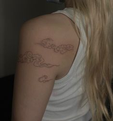 a woman with a cloud tattoo on her shoulder