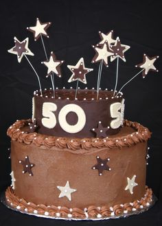 a chocolate cake with white stars on top and the number 50 on it's side