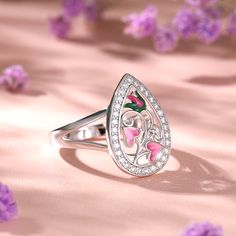 Reminiscent of the delicate garden, this ring has been carefully hand crafted in sterling silver, paying close attention to the intricate design of the flower. Bringing ring to life is cool leaf green and pink enamel detail. Bold on it own or great when paired with other complementary jewellery, this ring is incredibly versatile.Carat Weight: 2.25 ctStone Size: 1.5 mmNumber of Stones: 30 Stone Shape: RoundStone Color: Diamond WhiteWeight: 4.57 gWidth: 2.6 mmHeight: 6.1 mmThickness: 1.2 mmMaterial: 925 SilverPlating Color: Silver Sterling Silver Pink Flower Promise Ring, Pink Sterling Silver Flower Promise Ring, Sterling Silver Flower Ring In Pink, Pink Flower-shaped Sterling Silver Ring, Pink Flower Shaped Sterling Silver Ring, Pink Flower Sterling Silver Ring, Silver Flower Enamel Ring As A Gift, Pink Sterling Silver Flower Ring As Gift, Pink Sterling Silver Flower Ring For Gift