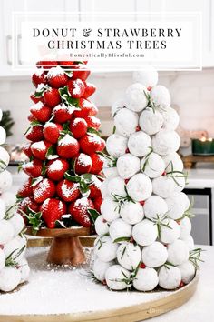 strawberries are stacked on top of each other in front of a christmas tree made out of marshmallows