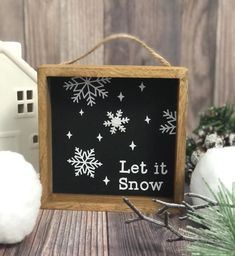 a chalkboard with snowflakes and let it snow written on it next to cotton balls