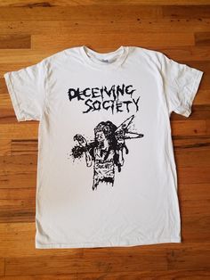 "Shirt screenprinted by me. Currently Made to order. The design is 11\" Wide and 15\" Top to bottom. The design is printed on Unisex Gildan Heavy cotton 100% Pre-shrunk Cotton shirts. I currently use Waterbased black ink. *No matter what shirt size you order the design will stay the same size. *shirt in pic is Medium" White Band Merch Shirt With Screen Print, White Screen Print Band Merch Shirt, Band Merch Shirt With Sublimation Print And Crew Neck, Unisex Fan Merchandise Shirt With Screen Print, Band Merch Shirt With Sublimation Print And Relaxed Fit, Band Merch Crew Neck Shirt With Sublimation Print, Unisex Screen Print Shirt For Fan Merchandise, Unisex Band Merch T-shirt With Screen Print, Band Merch Cotton T-shirt With Custom Print