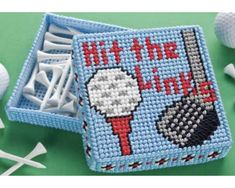 a needle - embroidered pin cushion with golf balls and tees