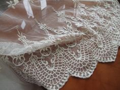 an image of white lace on a table cloth with some fabric around it that looks like something out of the victorian era