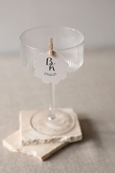 a glass with a label on it sitting on top of a table next to a napkin