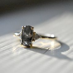 two stone ring sitting on top of a piece of white paper next to a window