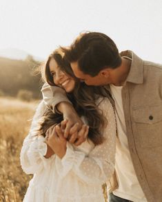 a man and woman hugging in a field