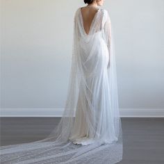 the back of a woman's wedding dress, with beaded detailing on it