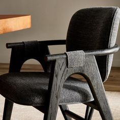 a black chair sitting in front of a wooden table