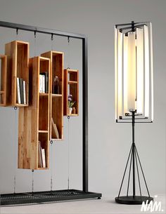 a lamp that is sitting next to a book shelf with books on it and a light hanging from the ceiling