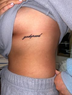 a person with a tattoo on their back that says, poopied in cursive writing