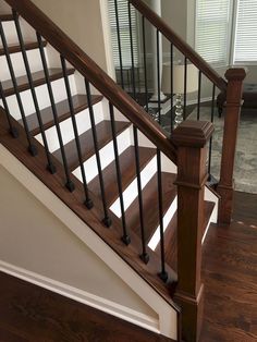 a wooden stair case next to a glass door