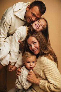 three adults and two children are posing for a family photo with their arms around each other