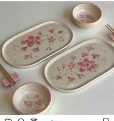 three dishes with chopsticks on them and one has pink flowers painted on it