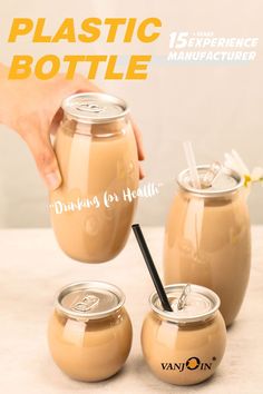 a person is holding a drink in front of three jars