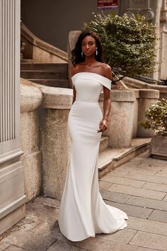 a woman in a white dress standing on steps