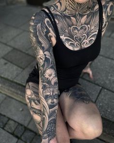 a woman with tattoos sitting on the ground