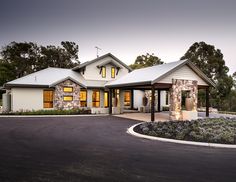 a house with a driveway in front of it and landscaping around the entrance to the home