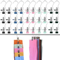 several pairs of colorful socks hanging from hooks on a wall with clips attached to them