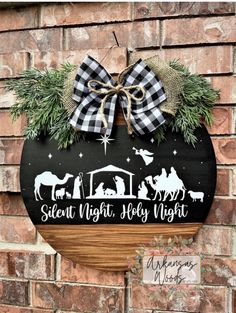 a wooden sign hanging on the side of a brick wall with christmas decorations around it