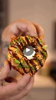 a person holding a doughnut with toppings on it