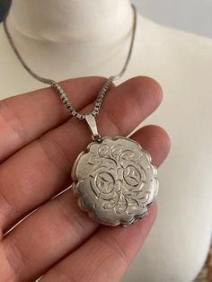 It is a English hallmarked, vintage, round, ornate, locket/pendant, with a silver chain, there is a silver hallmark on the clasp, weight 23 g, pendant height 4.2 cm, 3.2 cm diameter, chain is 55 cm long, in a good condition.