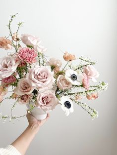 a person holding a bouquet of flowers in their hand