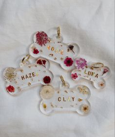 three bone shaped key chains with flowers on them