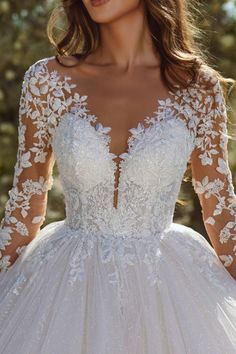 a woman wearing a wedding dress with long sleeves