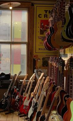 guitars are lined up in front of a window