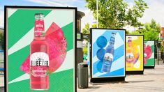 a group of advertising signs on the side of a road with trees in the background