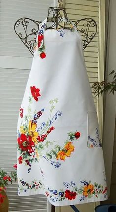 an apron hanging from a rack with flowers on it