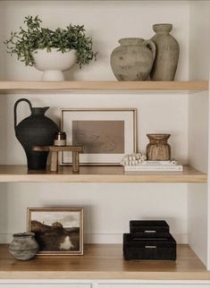 some shelves with vases and pictures on them