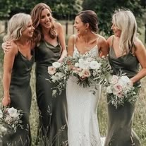 bridesmaids laughing together in the field with their bouquets