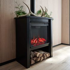 a black fireplace with red flames and antlers on top