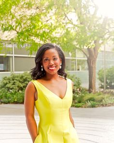 a woman in a yellow dress is posing for a photo with her hands on her hips