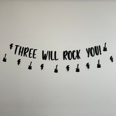 there is a sign that says three will rock you on the side of a wall