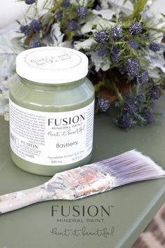 a green table topped with a jar of paint and a brush on top of it