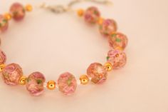 Secret Garden Hideaways or Tea Party Looks, the Verona Bracelet from our Italy Collection features sparkly pink and golden floral beads to complement a gorgeous classy look mixed with a cottage core feeling! *Product Information -Handmade -Bracelets are about 7.5 inches/19.05 centimeters long - (if applicable) some bracelets include a chain on the clasp section for an adjustable length -Bracelet includes a lobster clasp **Shipping & Returns -Ships from Texas -Please allow 2-3 weeks for processing and delivery -At this time, we do not accept exchanges or returns -Please do not hesitate to reach out regarding any questions or returns Care of Jewelry It is recommended that you do not swim, workout, shower/bathe while wearing this jewelry Elegant Orange Bracelet For Gift, Elegant Handmade Orange Bracelets, Orange Flower Bracelet For Gift, Adjustable Orange Bracelets For Weddings, Tea Party Looks, Swim Workout, Party Looks, How To Look Classy, Cottage Core