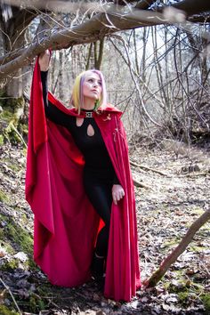 a woman in a red cape and black outfit