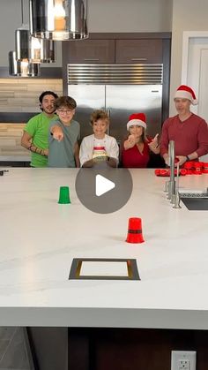 a group of people standing around a kitchen island with christmas decorations on the counter top