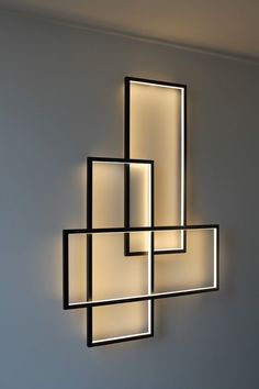 a wall mounted light fixture with square and rectangle shapes on it's sides