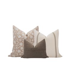 three pillows with different patterns on them, one is brown and the other is white