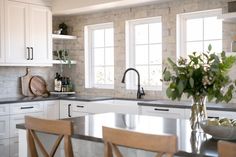 a kitchen with marble counter tops and white cabinets