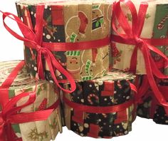 several rolls of christmas wrapping paper wrapped in red ribbon