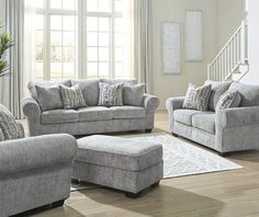 a living room filled with furniture and a stair case