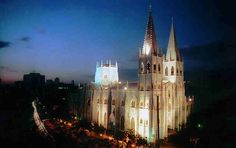 an aerial view of a cathedral lit up at night